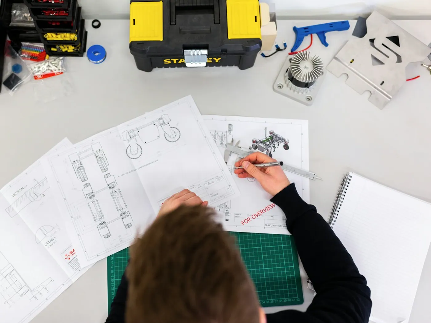 Planos de ingeniería y herramientas sobre una mesa de trabajo